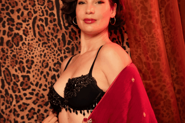 Fata Morgana en lingerie noire ornée de perles et kimono rouge, pose sensuelle devant un rideau léopard et des étoffes orangées, photographiée par Loraosa Pin You Up.
