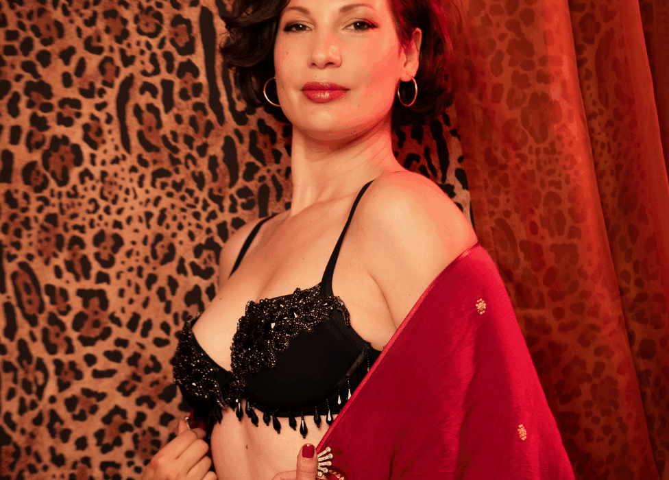 Fata Morgana en lingerie noire ornée de perles et kimono rouge, pose sensuelle devant un rideau léopard et des étoffes orangées, photographiée par Loraosa Pin You Up.