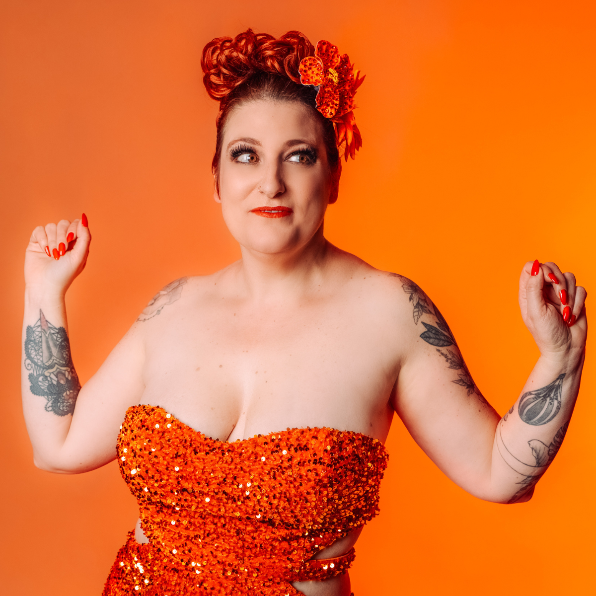 Portrait de Dotty Mac Lane, artiste burlesque française, vêtue d’un costume orange scintillant, photographiée par Studio Of Astra.