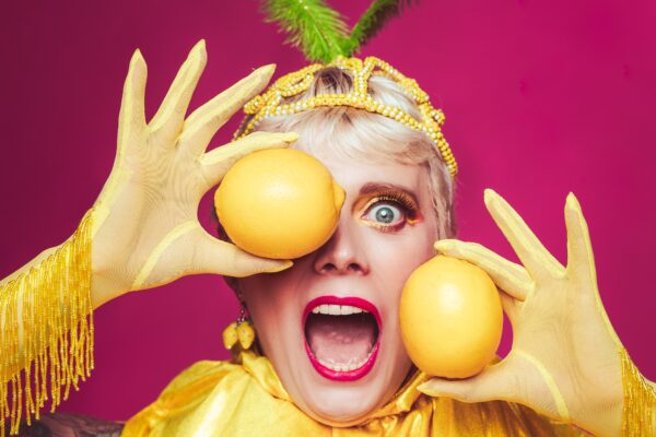 Peau Douce en costume doré, gants à franges et accessoires fruités, portrait coloré par Studio Of Astra