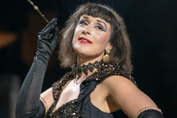 Portrait de l’artiste burlesque Roule Simone, maîtresse de cérémonie et effeuilleuse, en tenue de scène élégante, sur fond neutre.