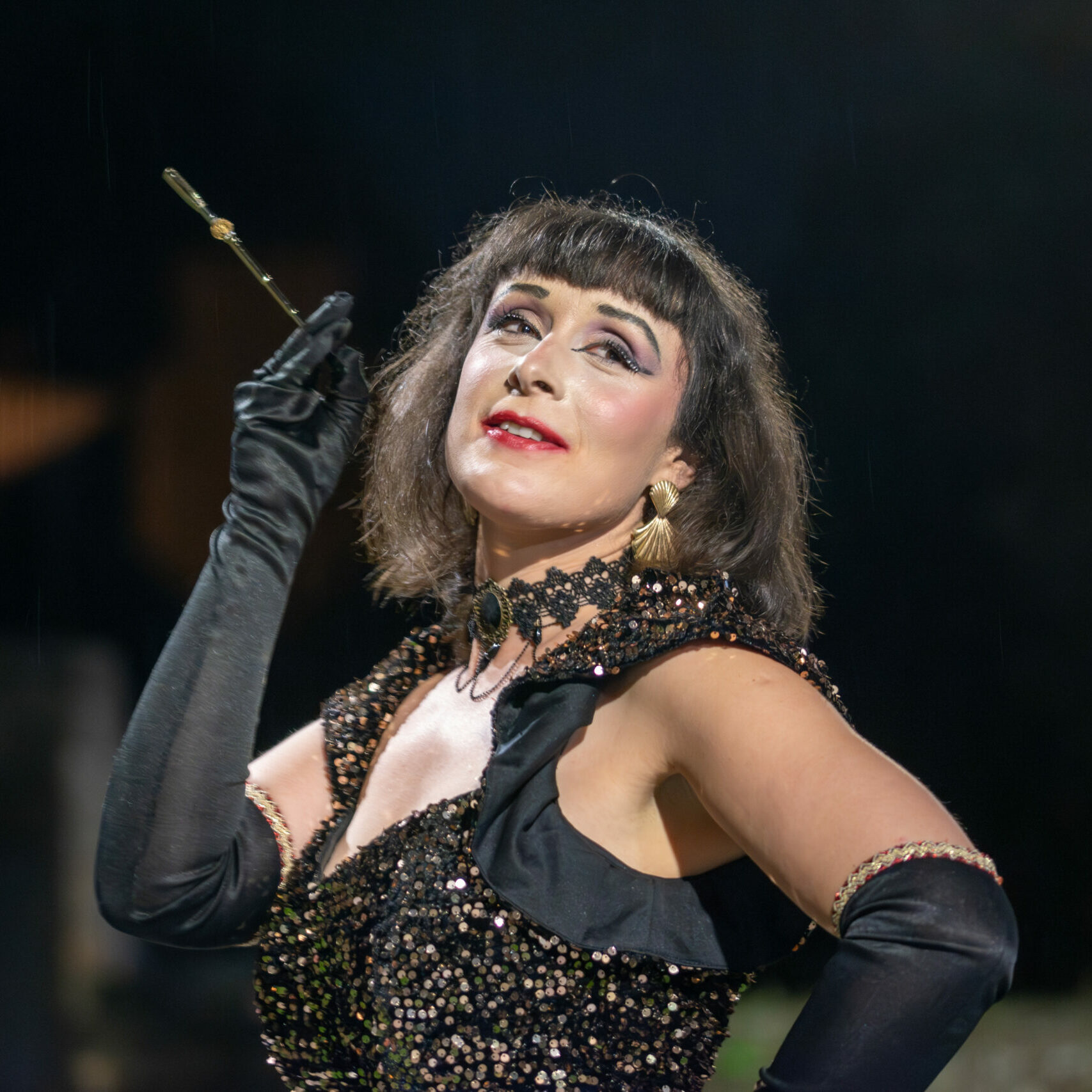 Portrait de l’artiste burlesque Roule Simone, maîtresse de cérémonie et effeuilleuse, en tenue de scène élégante, sur fond neutre.