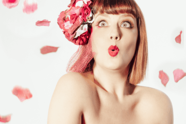 Cherry Lily Darling en robe bustier rouge ornée de pétales de fleurs, portrait burlesque élégant – Photo Eve Saint-Ramon