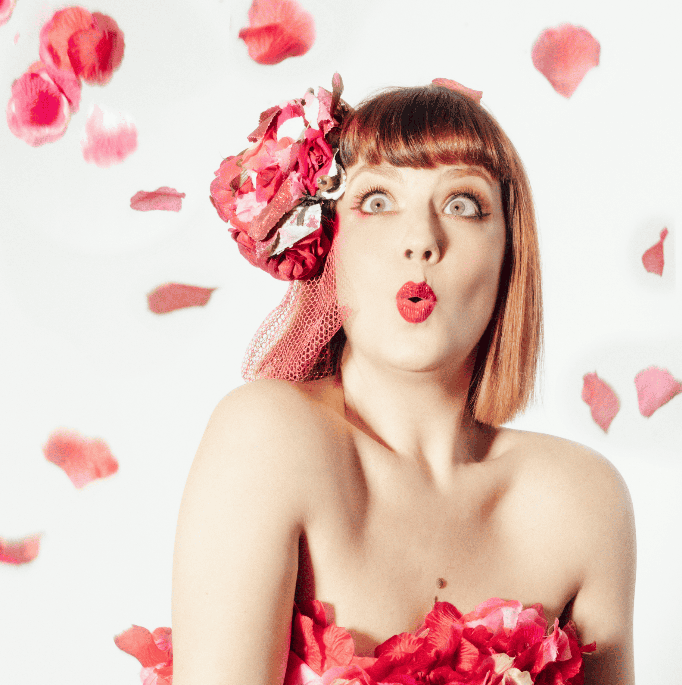 Cherry Lily Darling en robe bustier rouge ornée de pétales de fleurs, portrait burlesque élégant – Photo Eve Saint-Ramon