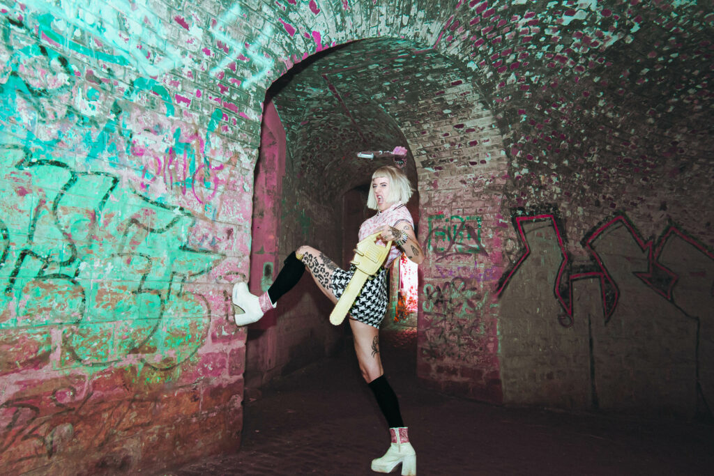 Tsunami Britney punk burlesque souterrain arches graffiti, jupe écossaise jaune bottes blanches plateforme. Photographe : Kalopsiary.