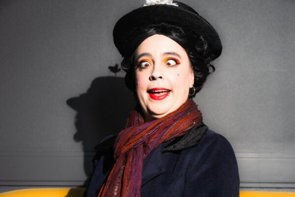 Marine Poppin's costumière effeuilleuse burlesque Rennes chapeau noir écharpe rouge maquillage théâtral canapé jaune