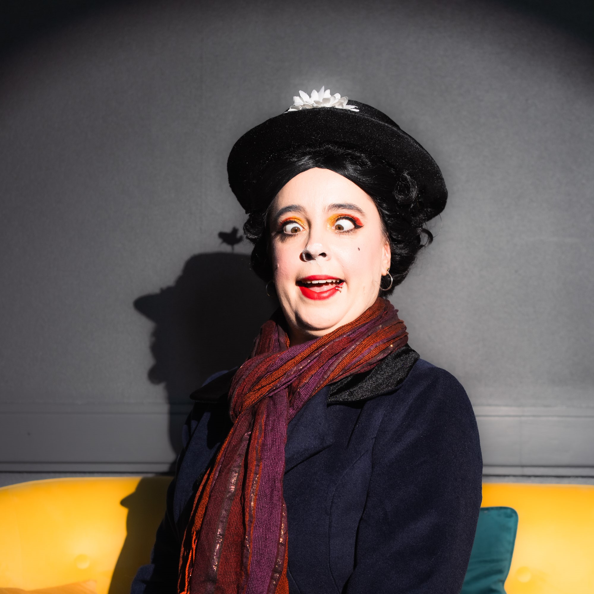 Marine Poppin's costumière effeuilleuse burlesque Rennes chapeau noir écharpe rouge maquillage théâtral canapé jaune